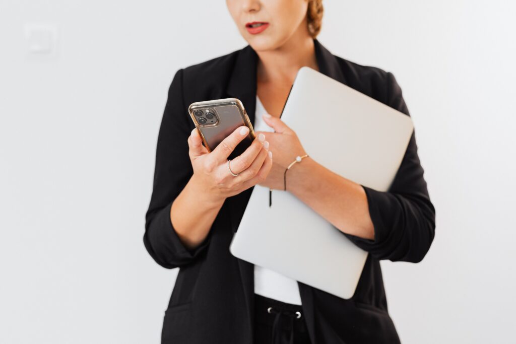 Kobieta trzymająca laptopa i telefon